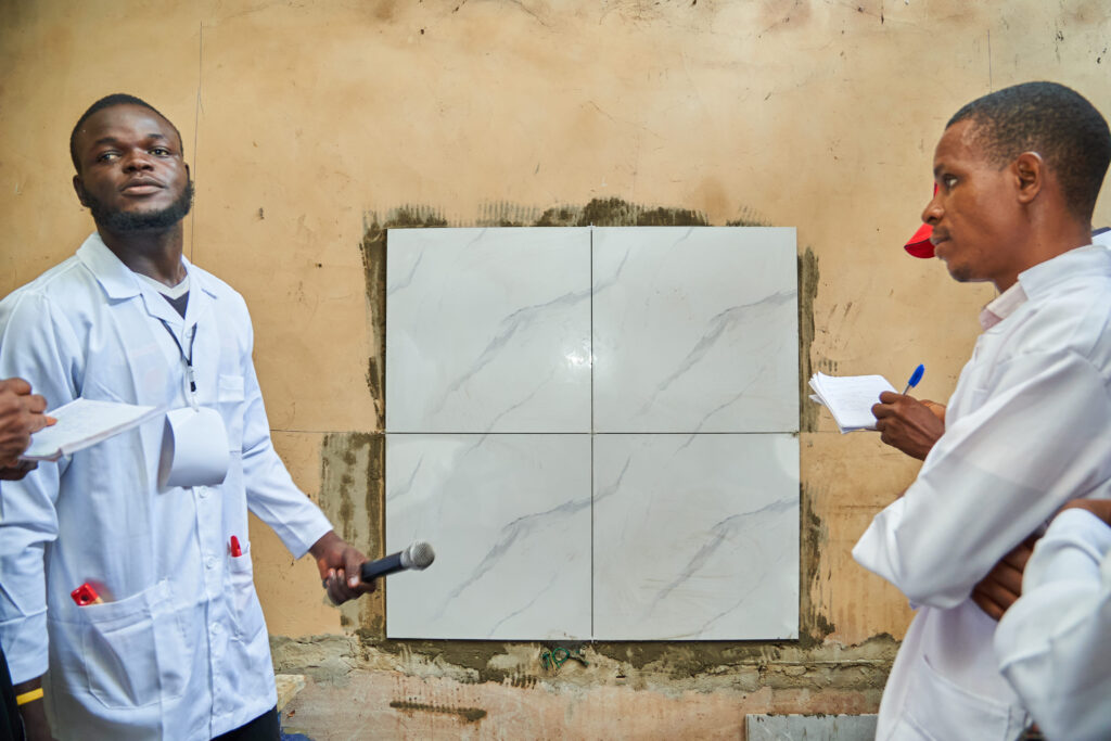 LIFE Africa Vocational Training Program - Tiling and construction trades practising tiling during the class